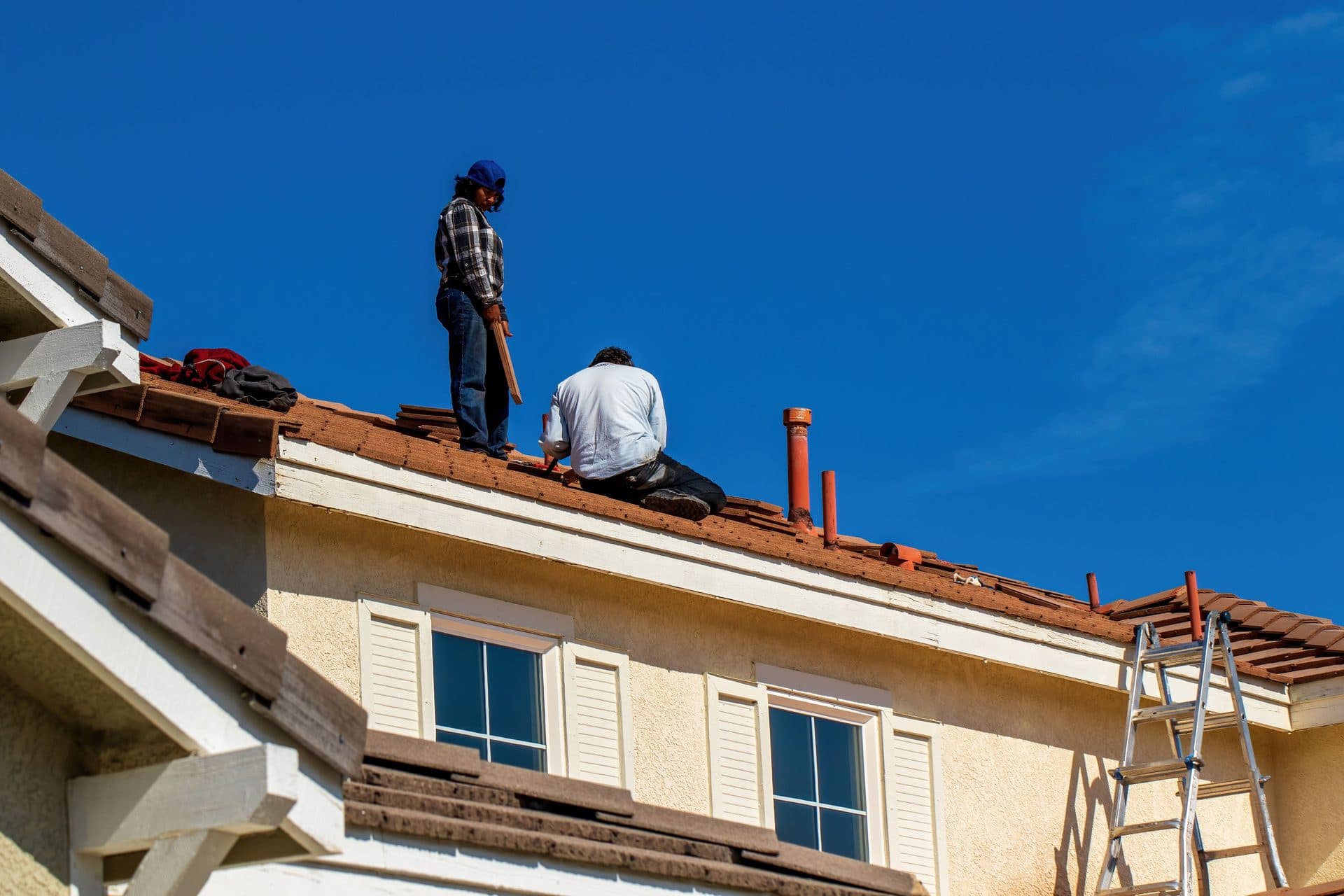 Roofers installing clay tile roofing